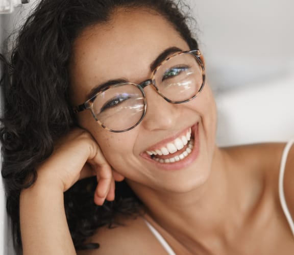 Woman leaning against a wall and smiling